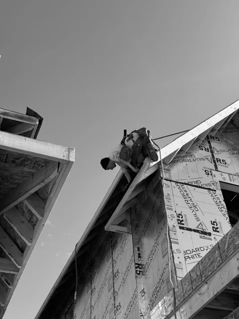 man installing roof on new home 